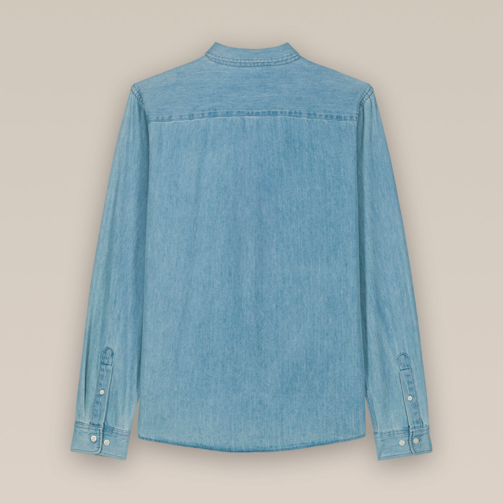 The back of a light wash blue men's denim shirt laid flat against a neutral background