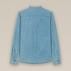 The back of a light wash blue men's denim shirt laid flat against a neutral background