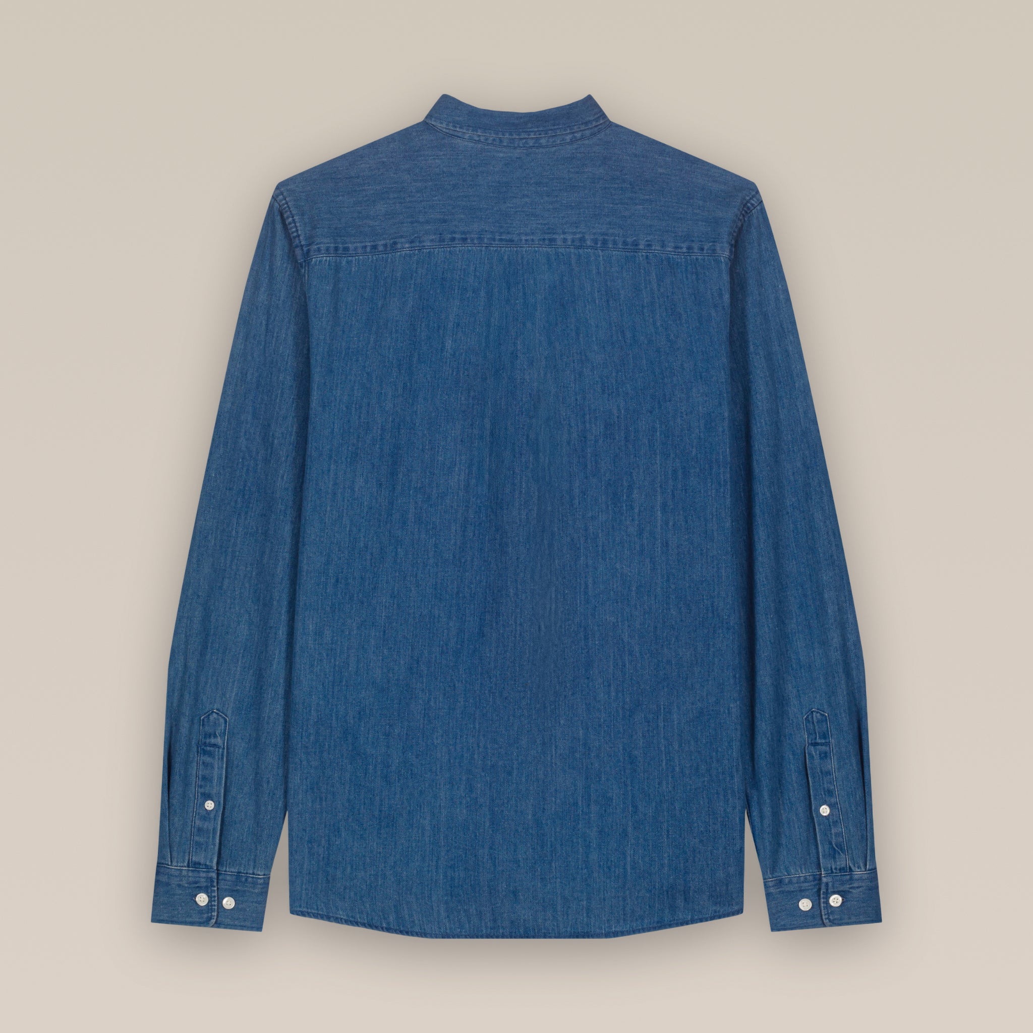 Back view of a mid wash blue men's denim shirt laid flat against a neutral background