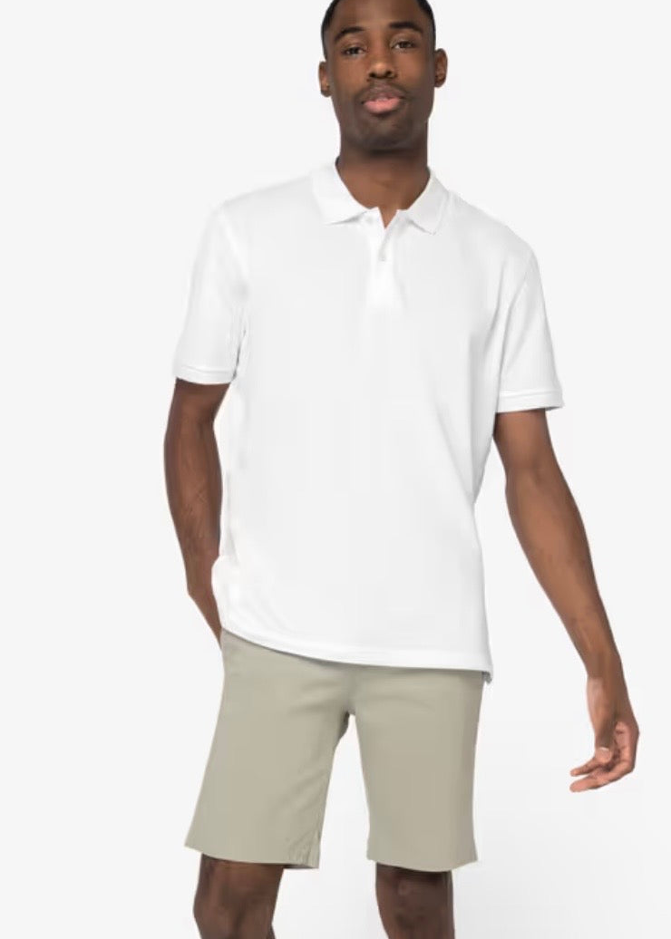 Image of a man wearing almond green chino shorts and a white polo shirt. The shorts fall just above the knees. The man is pictured against a neutral background.