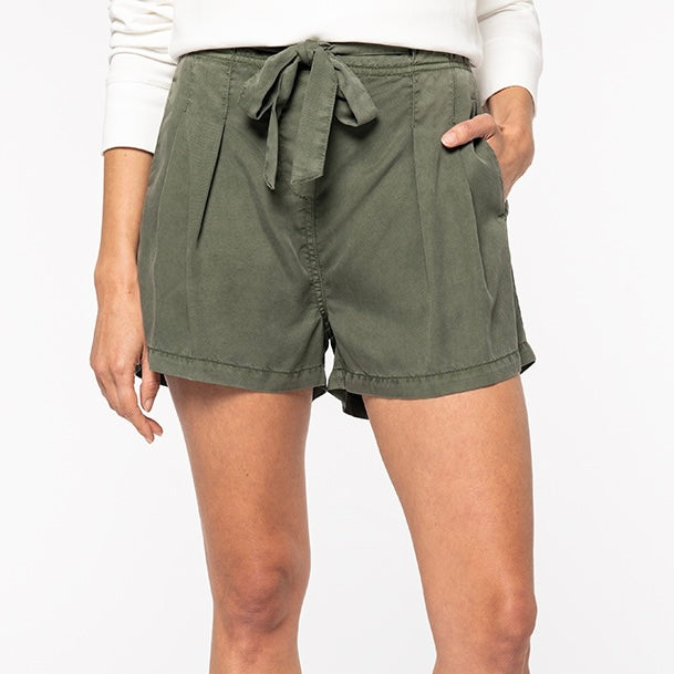 Image shows a woman wearing our khaki women's Tencel bow shorts against a neutral background.